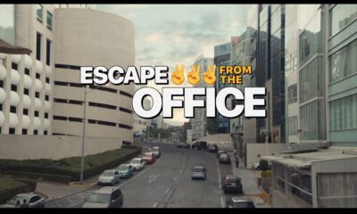 Titre du film Escape from the Office devant des immeubles en ville