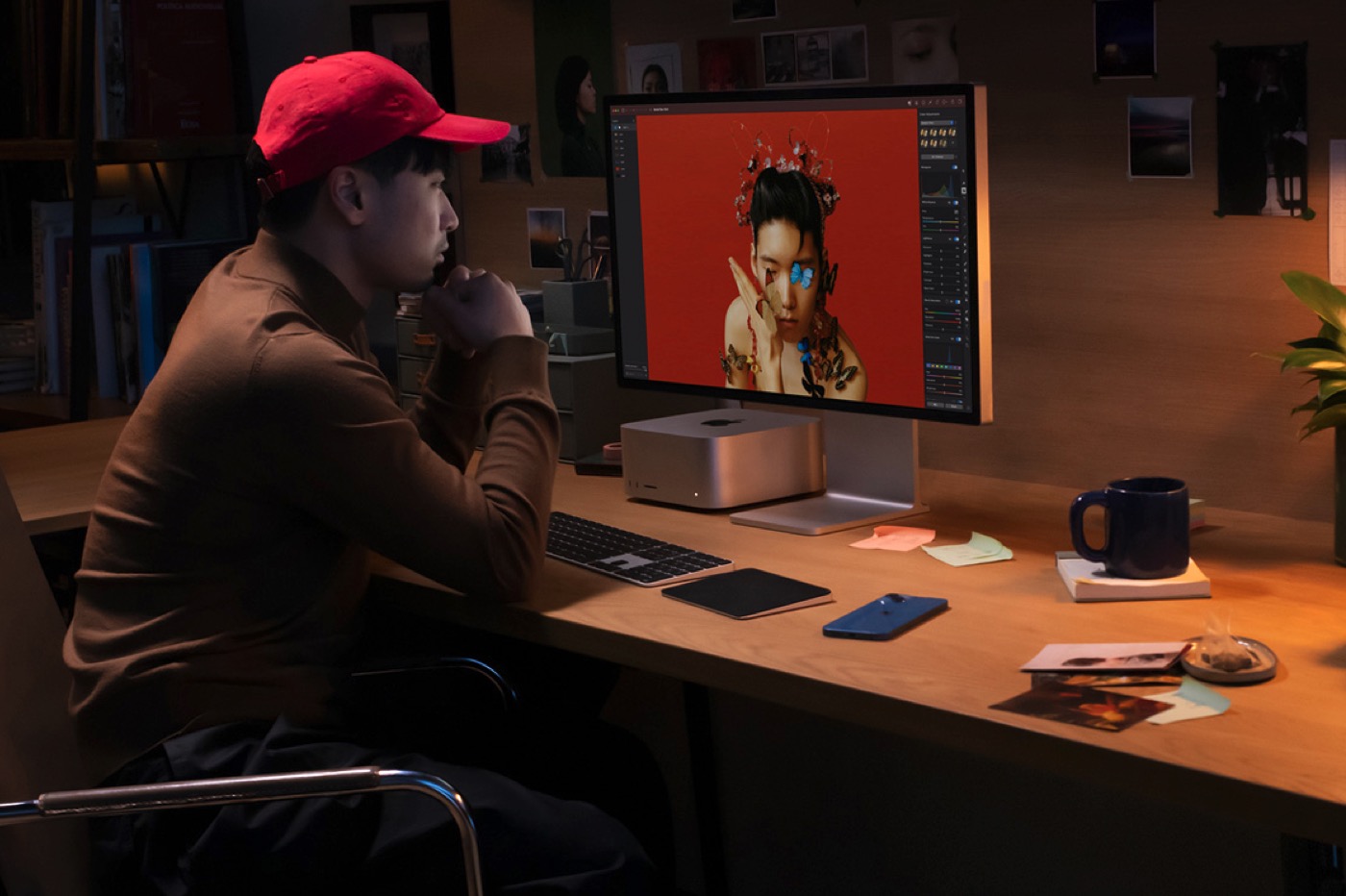 Personne avec casquette rouge travaillant sur Mac Studio