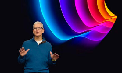 Tim Cook sur scène devant un fond avec pomme colorée