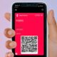 Main qui tient iPhone avec Apple Wallet et code QR de vaccination