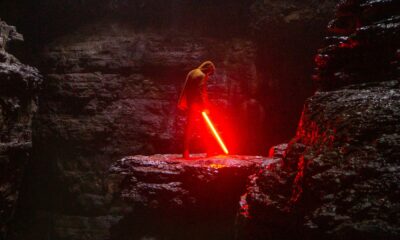 Personne tenant un sabre laser dans une grotte
