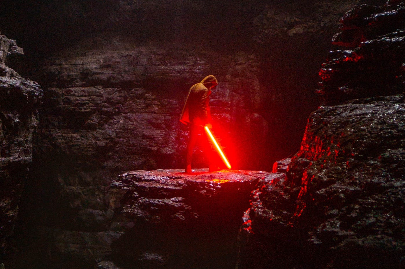 Personne tenant un sabre laser dans une grotte