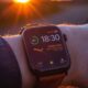 Apple Watch au poignet et soleil couchant