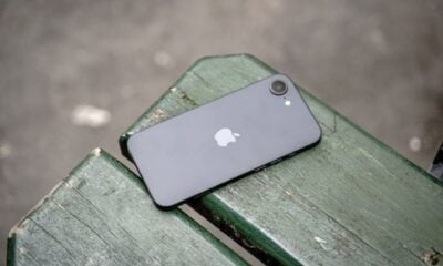 iPhone 16e noir posé sur un banc dos min